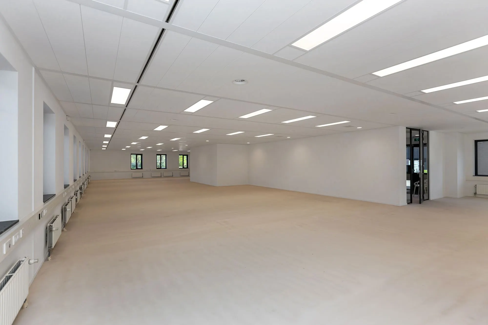 Ruime, lege kantoorruimte aan de Boris Pasternaklaan met witte muren, licht houten vloer en ingebouwde LED-verlichting.